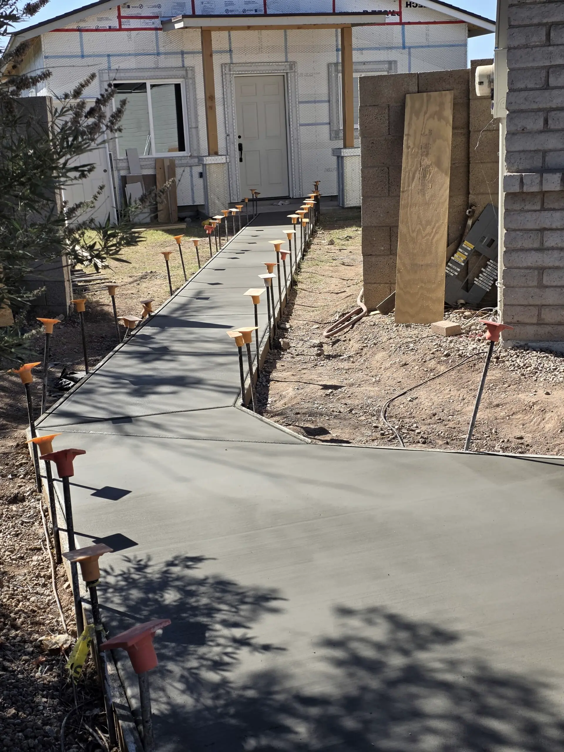A new sidewalk with its forms and stakes still in place